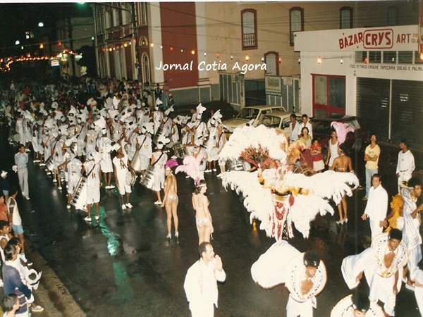 1986: Ala das baianas desfilando em frente à Praça da Matriz e o Bazar Crys ao fundo